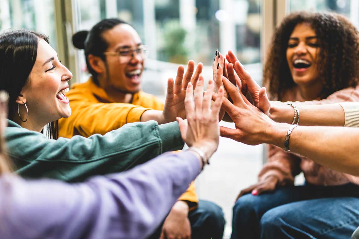 Multiracial happy young people stacking hands Group of diverse f